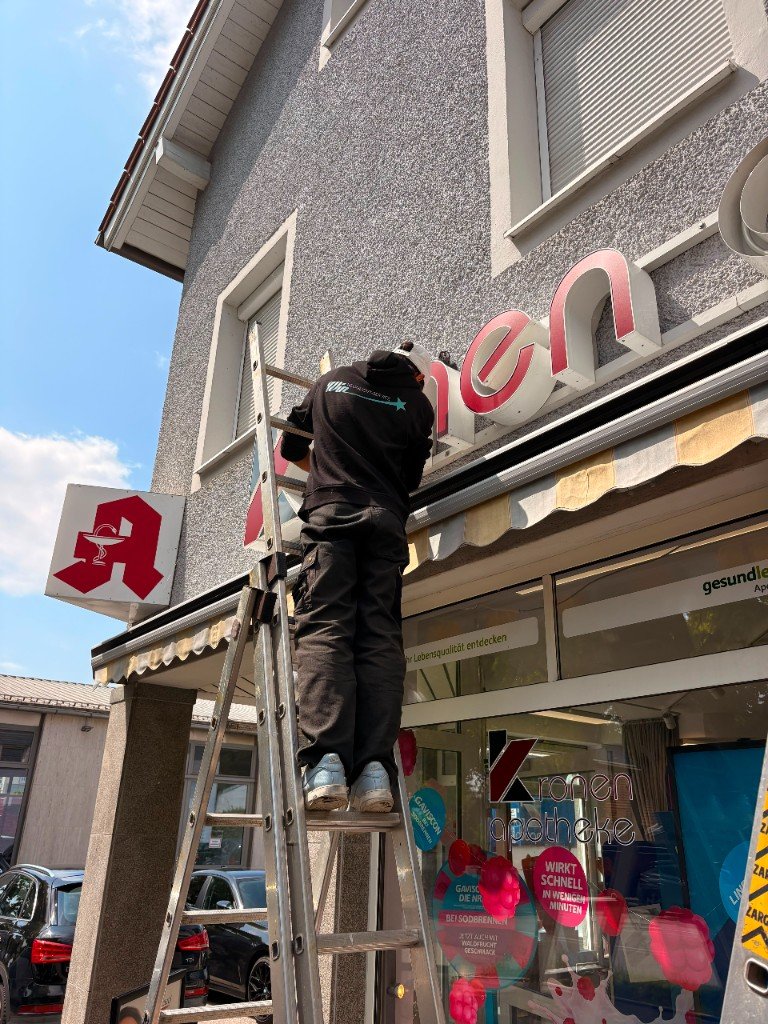 Monteur von Win Neonlicht-Service bei der Arbeit an einer Leuchtreklame